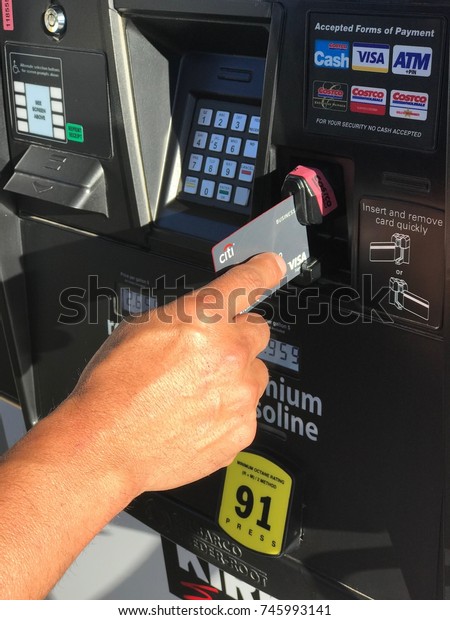 FOLSOM, CALIFORNIA, USA - OCT 4, 2017: Costco Gas\
Station, Man swiping credit card on gas station paying for gas with\
Citi Visa.
