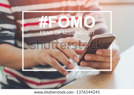 FOMO, fear of missing out concept. Close-up image of male hands using mobile smartphone
