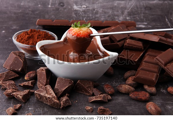 Fondue with Melting chocolate or melted\
chocolate and\
strawberry.
