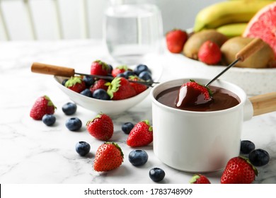 Fondue Pot With Chocolate And Fresh Berries On White Marble Table