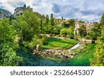 Fontaine de Vaucluse village with charming riverside in a picturesque town with colorful buildings during a peaceful afternoon. France, Provence, Vaucluse, Pays des Sorgues, Fontaine de Vaucluse.