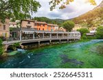 Fontaine de Vaucluse village with charming riverside in a picturesque town with colorful buildings during a peaceful afternoon. France, Provence, Vaucluse, Pays des Sorgues, Fontaine de Vaucluse.