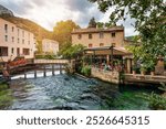 Fontaine de Vaucluse village with charming riverside in a picturesque town with colorful buildings during a peaceful afternoon. France, Provence, Vaucluse, Pays des Sorgues, Fontaine de Vaucluse.