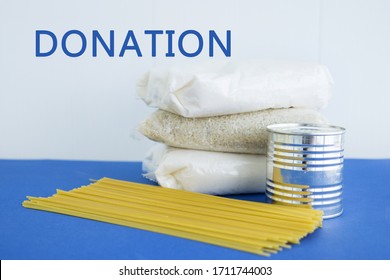 Food Aid During Quarantine. Products: Sugar, Rice, Pasta, Canned Food. Food Donation On A Blue Background.
