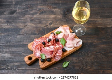 Food antipasti prosciutto ham, parma ham, salami, olives and bread.glasses of white wine or prosecco