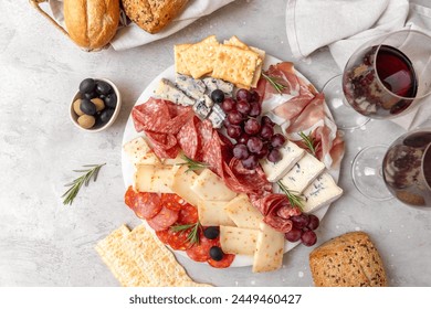 Food antipasto prosciutto ham, salami, olives and grissini bread sticks. cheese on a board parmesan, pecorino, gorgonzola. Charcuterie board. Two glasses of red wine - Powered by Shutterstock