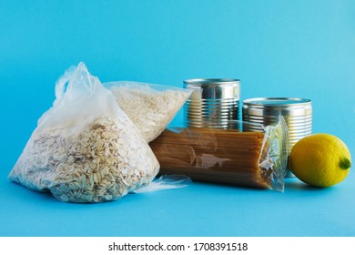 Food Assistance, Donations. Basic Necessities, Oatmeal, Rice, Pasta, Canned Food, Vegetables On A Blue Background.