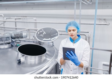 Food Automated Modern Industrial Production. Operator Worker Woman Checks Steel Tanks With Tablet Computer.