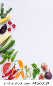 Food background border frame of colorful fresh produce raw vegetables, corn carrot chilli cucumber purple cabbage spinach rosemary herb, plenty of copy-space
