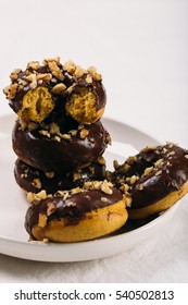 Food background of fresh baked gluten free chocolate glaze donuts in plate on white table Close up 
