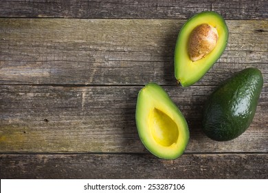 food background with fresh organic avocado on  old wooden table, top view, copy space