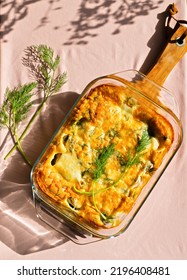 Food Background Of A Homemade, Healthy, Keto Casserole With Fresh Dill And A Crunchy Crust Against A Pink Background, No People. Vertical Image 
