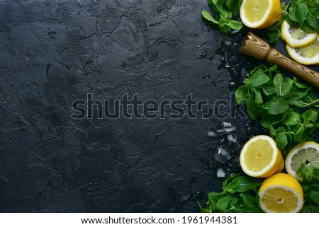 Food background with ingredients for making lemonade or citrus cocktail on a dark slate, stone or concrete background. Top view with copy space.