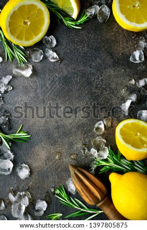 Food background with ingredients for making summer citrus lemonade or cocktail on a dark slate, stone or concrete backdrop. Top view with copy space.