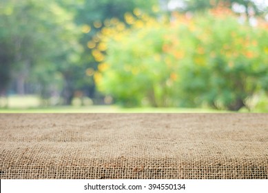 Food Background And Nature, Empty Table Product And Sack Tablecloth Over Blur Tree Park Garden With Bokeh In Spring And Summer Outdoor Background, Picnic Desk, Counter, Shelf For Product Display