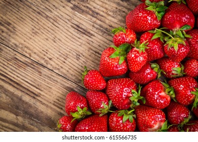food background with plenty of juicy strawberry on old wooden table and space for text in corner