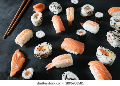 Food background set sushi roll  with salmon, avocado, cream cheese. Sushi menu. Japanese food. Black background. Top view. Food delivery coronavirus