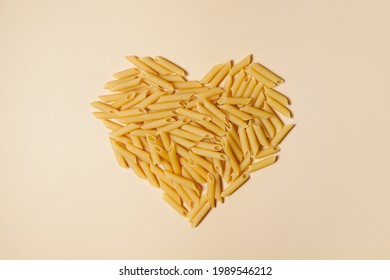 Food Background And Valentine Concept. Pasta In Shape Of Heart On Light Pink Background.