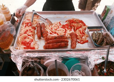 Food. Bacon Wrapped Hot Dogs. Grilled Onions and Peppers. Hot Dog Cart. Food Cart. Hot Dogs being cooked and offered for sale on the side walk of Hollywood California. Hungry Tourist enjoy Hot Dogs. - Powered by Shutterstock