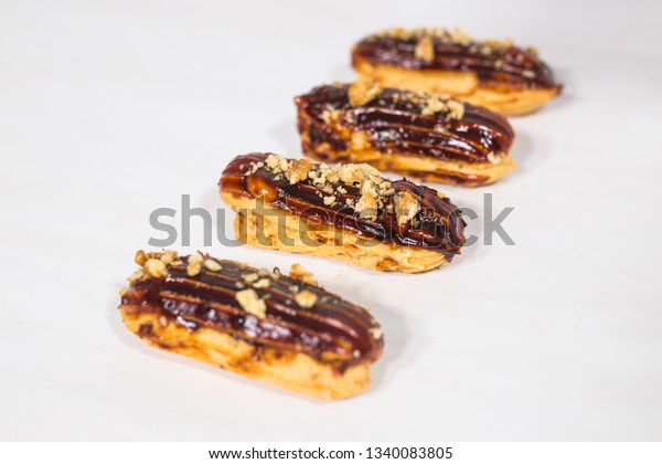 Food, bakery and desserts concept - row of
eclairs on white
background