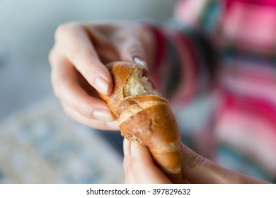 Food, Baking, People And Unhealthy Eating Concept - Close Up Of Woman Hands With Bun Or Wheat Bread