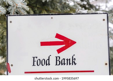 A Food Bank Sign With An Arrow On The Forest