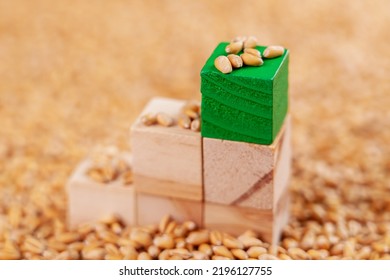 Food Business Concept. A Tower Of Wooden Toy Blocks With A Green Block On Top In A Pile Of Wheat Seeds