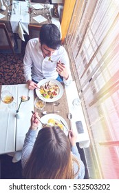 Food, Christmas, Holidays And People Concept - Smiling Couple Eating Main Course At Restaurant