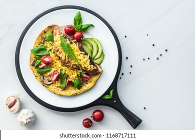 food composition with healthy omelette on wooden board on white marble tabletop