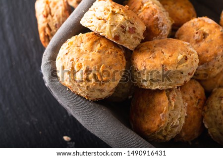 Food concept Fresh baked Homemade buttery, salty Ham and cheese scones on black background
