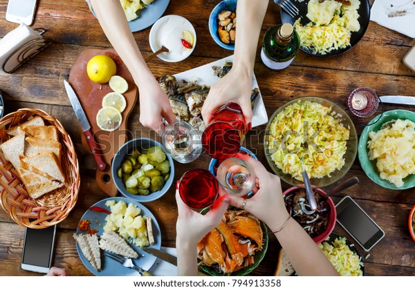 食べ物のコンセプトは 食べ物の違う食べ物を持つディナーテーブルの友達 復活祭 クリスマス 誕生日 感謝祭 祝祭日を祝って祝儀の杯と共に祝杯を挙げる の写真素材 今すぐ編集