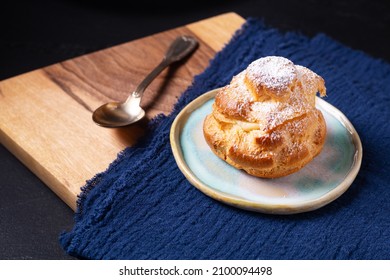 Food concept Homemade fresh baked Choux a la creme, Cream Puff, Choux Cream in white ceramic plate on black background with copy space