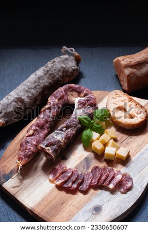 Food concept organic bio Saucisson French  dry-cured salamis or sausages on black slate stone background with copy space