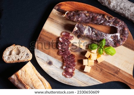 Food concept organic bio Saucisson French  dry-cured salamis or sausages on black slate stone background with copy space