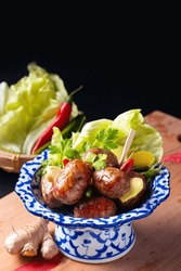 Food Concept Sai Krok Isan Or Isaan Thai-Laos Fermented Pork And Rice Sausages In Tradition Thai Ceramic Pedestal Plate On Black Background With Copy Space