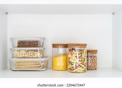 food containers with plastic lid different size at kitchen cupboard, storage of pasta, grains, chickpeas and oats in glassware kitchenware