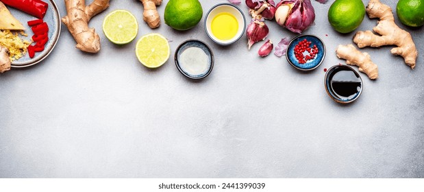 Food and cooking background with fresh raw vegetables. Gray table with paprika, zucchini, spices and ingredients for cooking Asian dishes with ginger, garlic, soy sauce and lime, top view banner  - Powered by Shutterstock