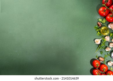 Food Cooking Preparation Background. Kitchen Table Background With Spices, Herbs, Vegetables. Parsley, Onion, Garlic, Tomatoes, Salt, Olive Oil On Dark Green Background Top View Flatlay Copy Space