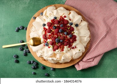 Food, Culinary, Baking And Cooking Concept - Close Up Of Pavlova Meringue Cake Decorated With Berries On Wooden Serving Board And Kitchen Towel