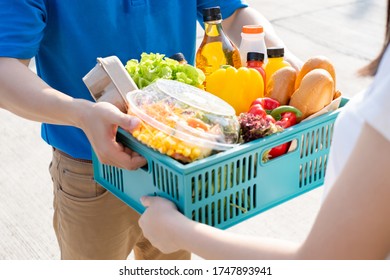 Food Deliver Asian Man In Blue Uniform Give Fruit And Vegetable To Receiver Customer Front House, Fast Express Grocery Service When Crisis Coronavirus