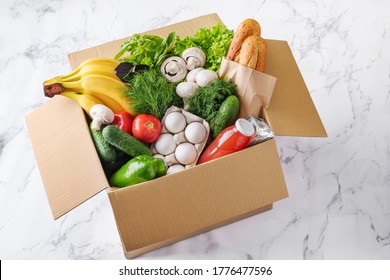 Food delivery in a box. Fruits, vegetables, eggs, mushrooms and bread in a box for delivery. - Powered by Shutterstock