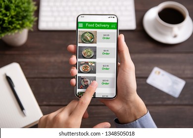 Food delivery. Businessman choosing meal for lunch in takeaway restaurant service on mobile application on smartphone - Powered by Shutterstock