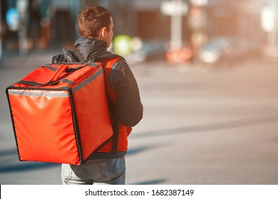 Сontactless food delivery to customers home. Delivery service worker with thermal backpack quick delivering food at doorstep in quarantine from restaurant, supermarket or cafe . Online ordering food - Powered by Shutterstock