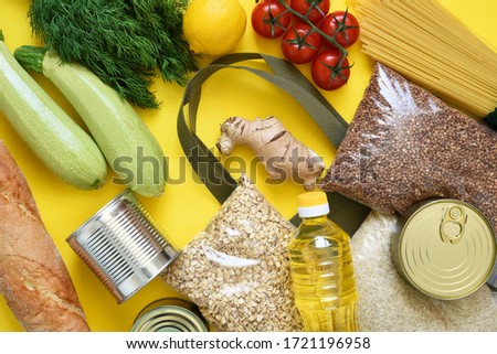 Food delivery. Food donations: vegetables, groceries, preservation on a yellow background. Sit at home. Pandemic relief.