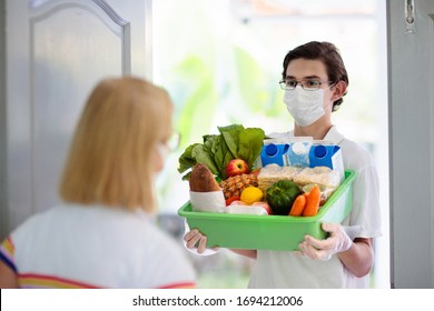 Food Delivery During Corona Virus Outbreak. Courier Wearing Face Mask Delivering Grocery Order In Coronavirus Epidemic. Safe Shopping In Pandemic. Takeout Meal. People Stockpile Food.