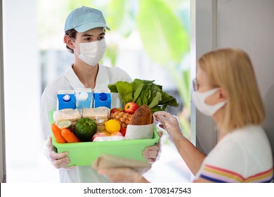 Food Delivery During Corona Virus Outbreak. Courier Wearing Face Mask Delivering Grocery Order In Coronavirus Epidemic. Safe Shopping In Pandemic. Takeout Meal. People Stockpile Food.