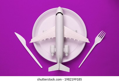 Food Delivery. Fgurine Of Airplane In Plate With Fork And Knife On Pink Background. Top View