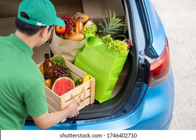Food Delivery man giving fruit and vegetable shopping supermarket to receiver customer front house from truck car, express grocery service when coronavirus crisis covid19 new normal lifestyle 