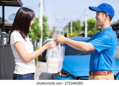 Food Delivery Man Handing Plastic Bags Shopping Online From Supermarket To Female Client Service Customer Front House, Express Grocery When Covid19 New Normal Lifestyle.