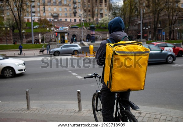 Food Delivery Man On Bike With Yellow Bag Drive In\
Urban City